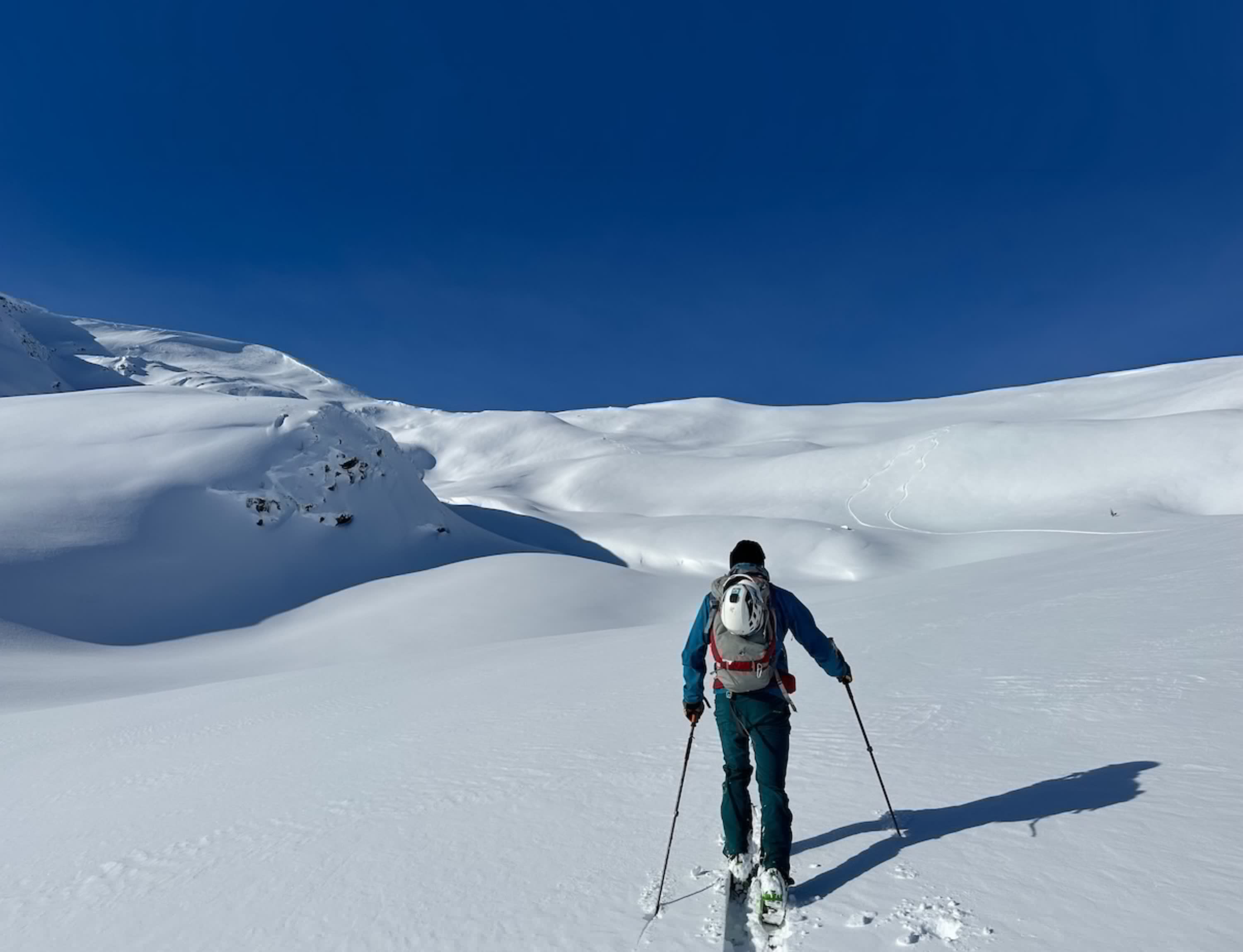 Image of person ski touring uphill on a mountain.